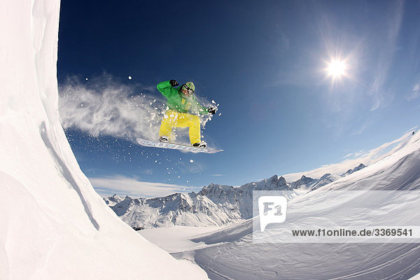 Berg Winter Snowboard Snowboarding Geschwindigkeit Mensch springen Gegenlicht Kanton Graubünden Tiefschnee Schnee Sonne Schweiz Wintersport