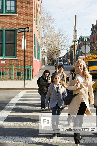 Teacher and pupils crossing road
