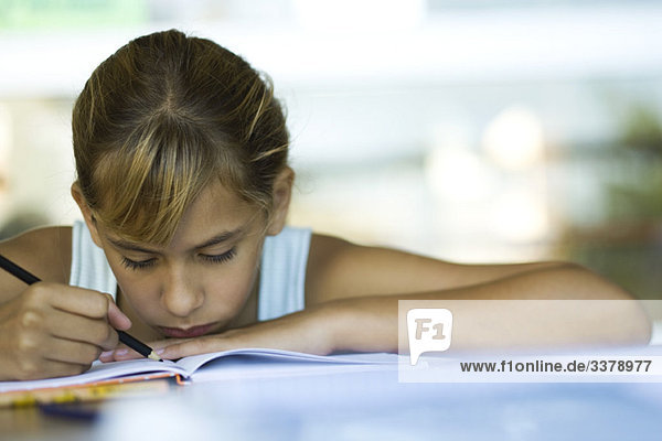 Weibliche Mittelschülerin beim Schreiben von Hausaufgaben