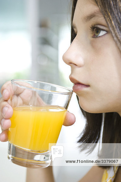 Mädchen trinken ein Glas Orangensaft