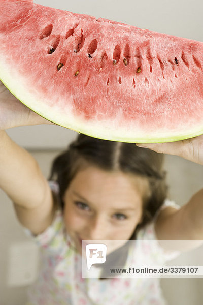 Mädchen hält Scheibe Wassermelone hoch