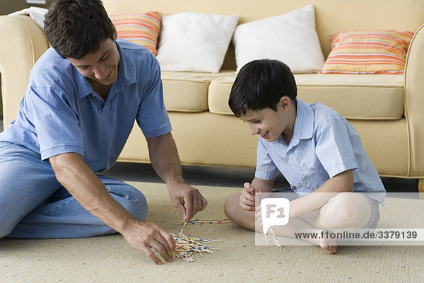 Father and son playing pick up sticks