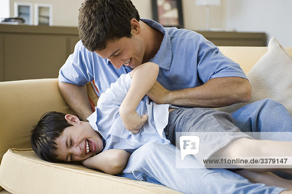 Father tickling young son