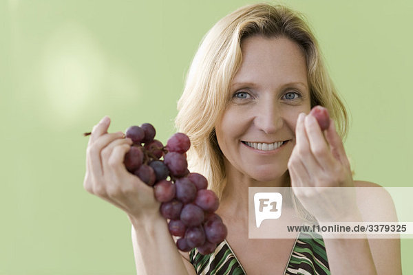 Mature woman eating grapes