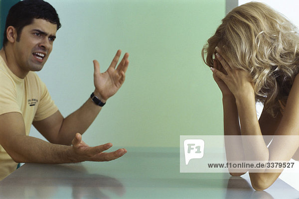 Paar streitet sich am Tisch  Frau hält Kopf