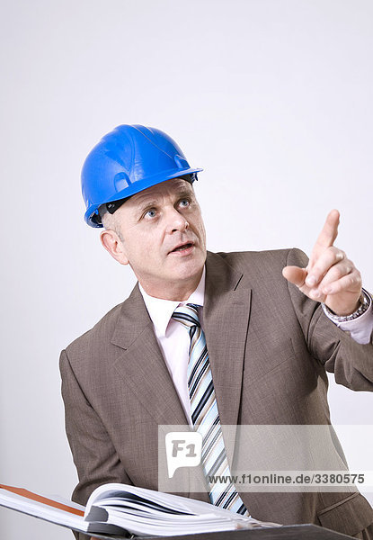 Businessman wearing hard hat  holding filing folder