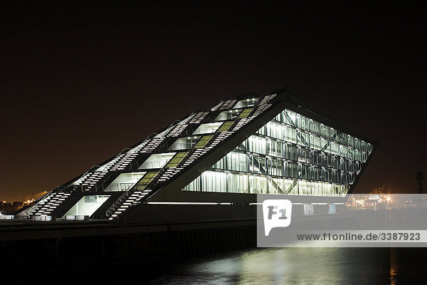 Beleuchtetes Bürogebäude am Flussufer bei Nacht  Hamburg  Deutschland