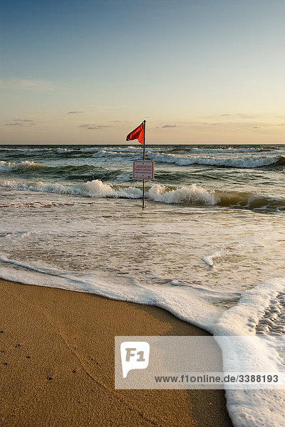 Rote Fahne und Warnschild an der Nordseeküste  Rantum  Sylt  Deutschland
