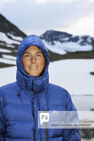 Eine Frau in einem blauen gesteppte Daunenjacke  Lappland  Schweden.