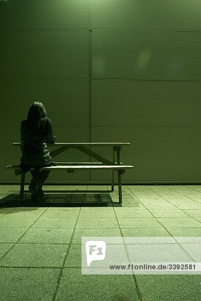 einsame Frau auf der Bank sitzend