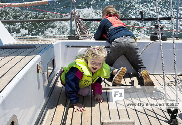 Boy and girl playing on a sailing yacht  elevated view