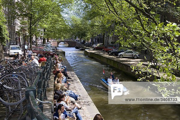 Menschen am Ufer der Leliegrachtgracht sitzend  Amsterdam  Niederlande  Erhöhte Ansicht