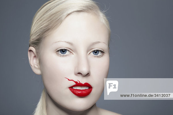 Junge Frau mit verwischtem roten Lippenstift  Portrait mund