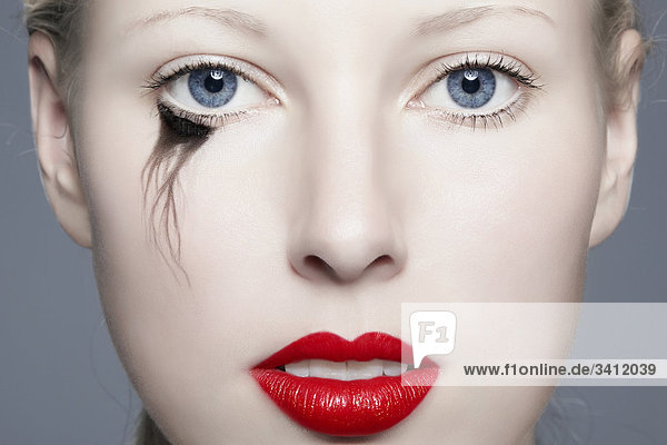 Junge Frau mit roten Lippen und verwischtem Eyeliner  Portrait mund