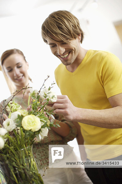 Junges Paar  das Blumen arrangiert