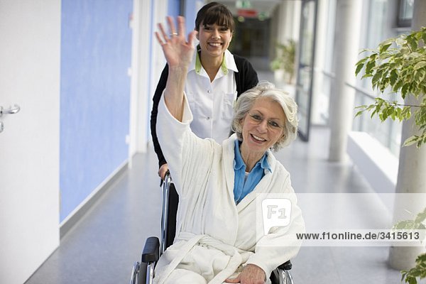 Alte Frau im Rollstuhl und Krankenschwester
