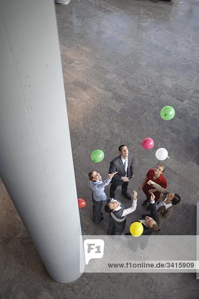 Business-Team setzt farbige Luftballons frei