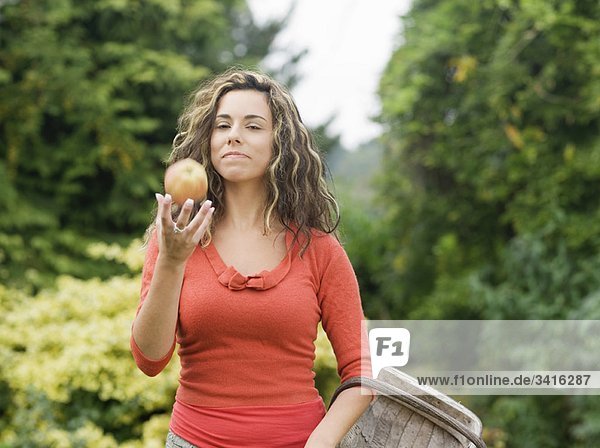 Frau hält Korb mit Apfel in der Hand