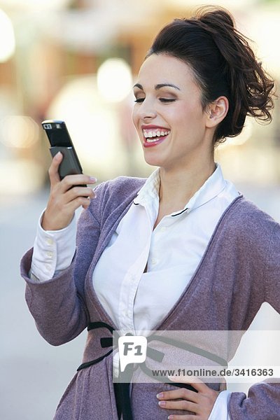Eine Frau  die über eine SMS lacht.