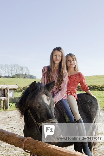 Zwei Mädchen zu Pferd