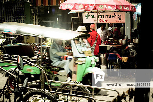 Autorikscha (Tuk-Tuk) vor einem Imbissstand  Bangkok  Thailand