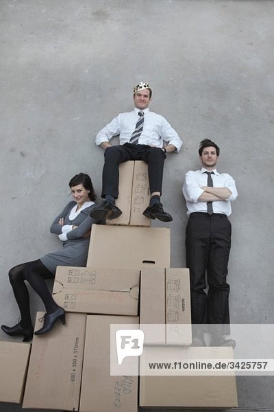 Three business people  businessman wearing crown  smiling  portrait
