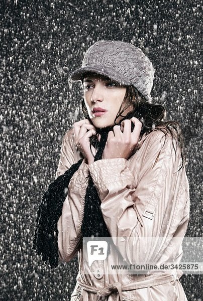 Woman standing in rain  looking away.