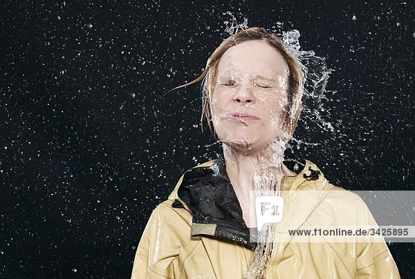 Woman enjoying splash of water  eyes closed.