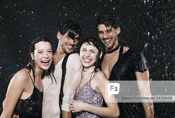 Friends enjoying in rain  smiling  portrait.
