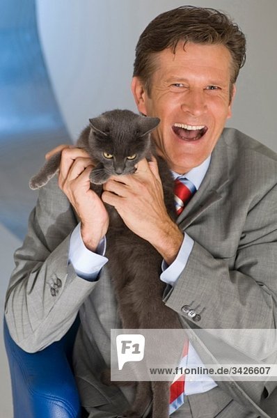 Geschäftsmann hält Katze  lachend  Portrait