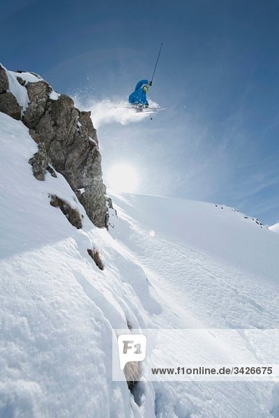 Austria  Arlberg  Man skiing downhill  doing jump  low angle view