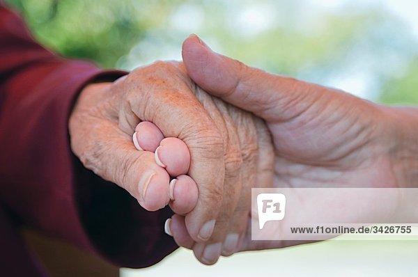 Seniorinnen halten sich an den Händen  Nahaufnahme
