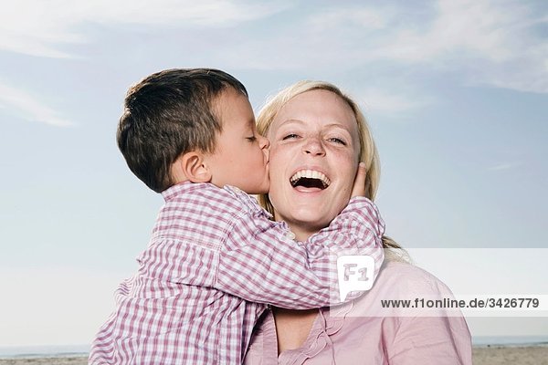Germany  Schleswig Holstein  Amrum  Son (3-4) kissing mother  laughing  portrait