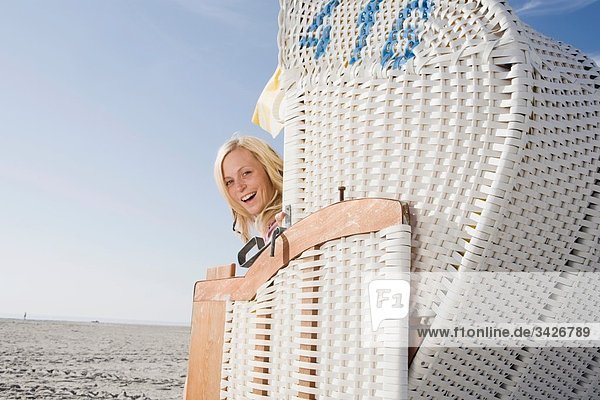 Deutschland  Schleswig Holstein  Amrum  Frau im Strandkorb sitzend  lachend  Porträt