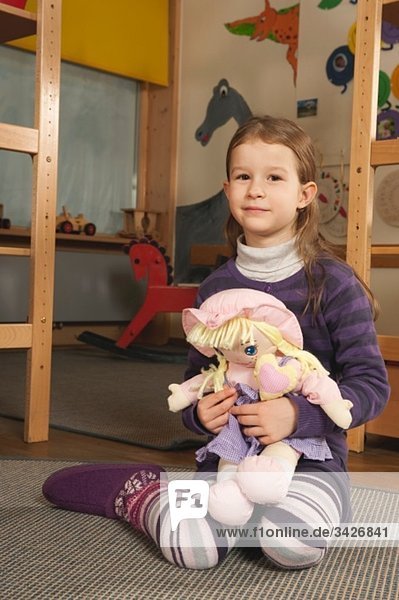 Germany  Portrait of a girl (4-5) in nursery holding doll
