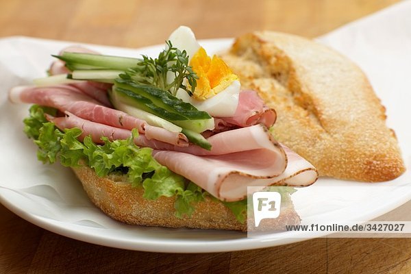 Sandwich mit gekochtem Schinken  Eiern  Kresse und Gurkenscheiben  Nahaufnahme