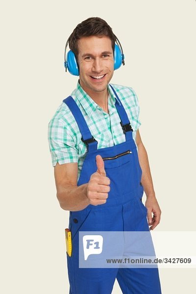 Mann mit Ohrenschützer mit Daumen nach oben  lächelnd  Portrait