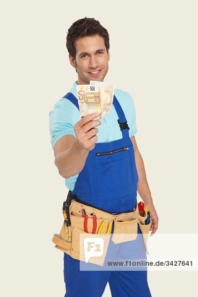Mann trägt Werkzeuggürtel mit Währung  lächelnd  Portrait