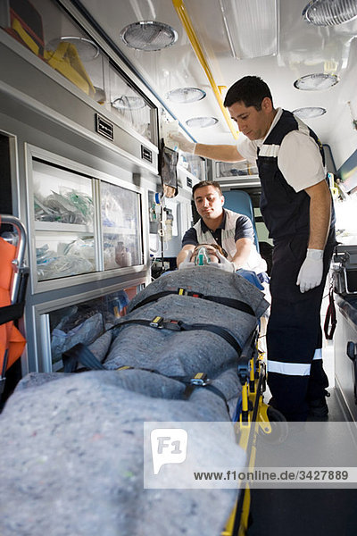 Ambulanzpersonal und Patient auf Trage