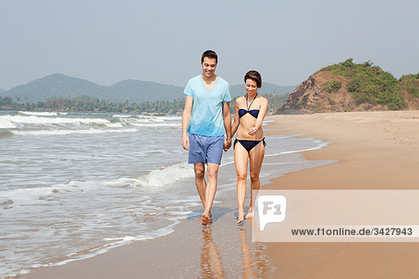 Couple walking by the ocean