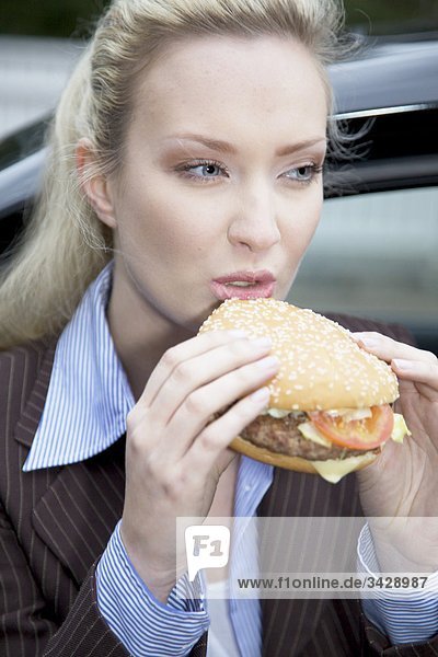Geschäftsfrau isst einen Hamburger
