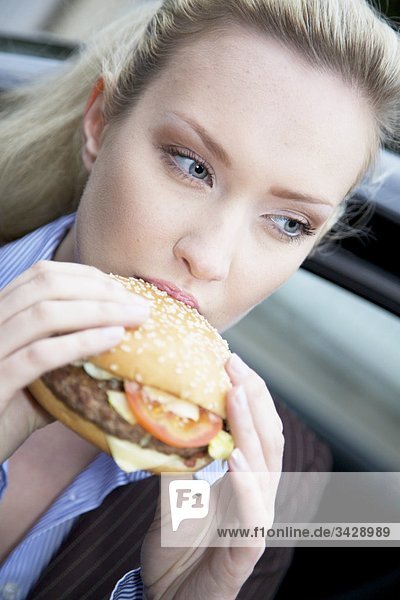 Geschäftsfrau isst einen Hamburger  Close-up