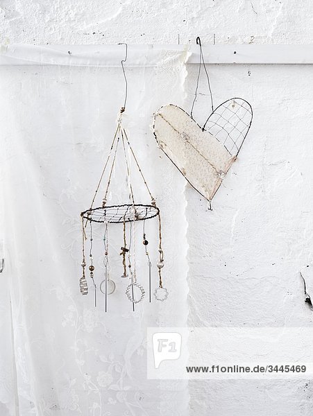 Scandinavia  Sweden  Stockholm  Heart shape and wind chime hanging against white wall