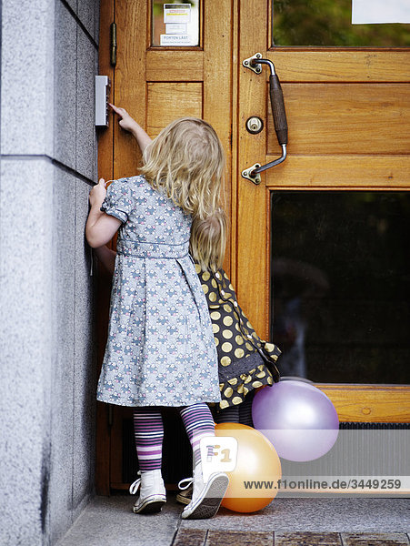 Scandinavia  Sweden  Stockholm  Girls pushing doorbell  rear view