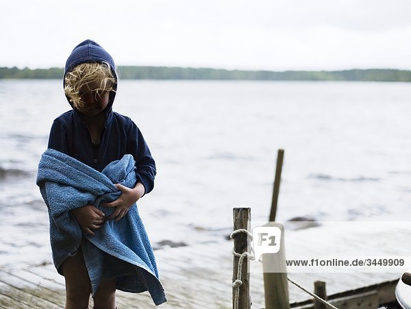 Girl wrapped in towel  standing on jetty