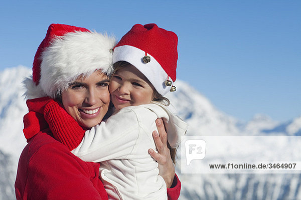 Mutter und tragen Nikolausmützen  umarmend