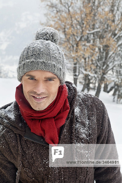 Young man in winter clothes smiling at camera