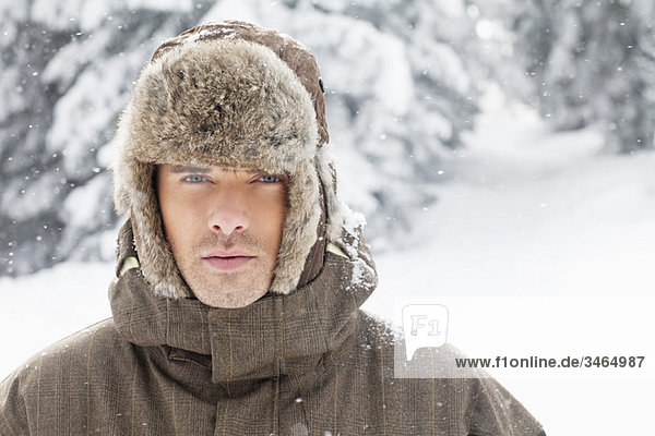 Junger Mann in Winterkleidung mit Blick auf die Kamera