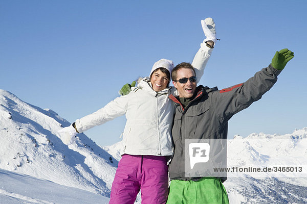 Junges Paar in Skikleidung  lächelnd vor der Kamera