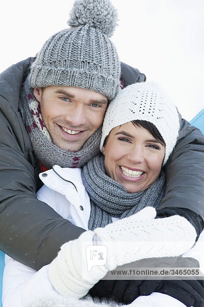 Junges Paar in Winterkleidung umarmend